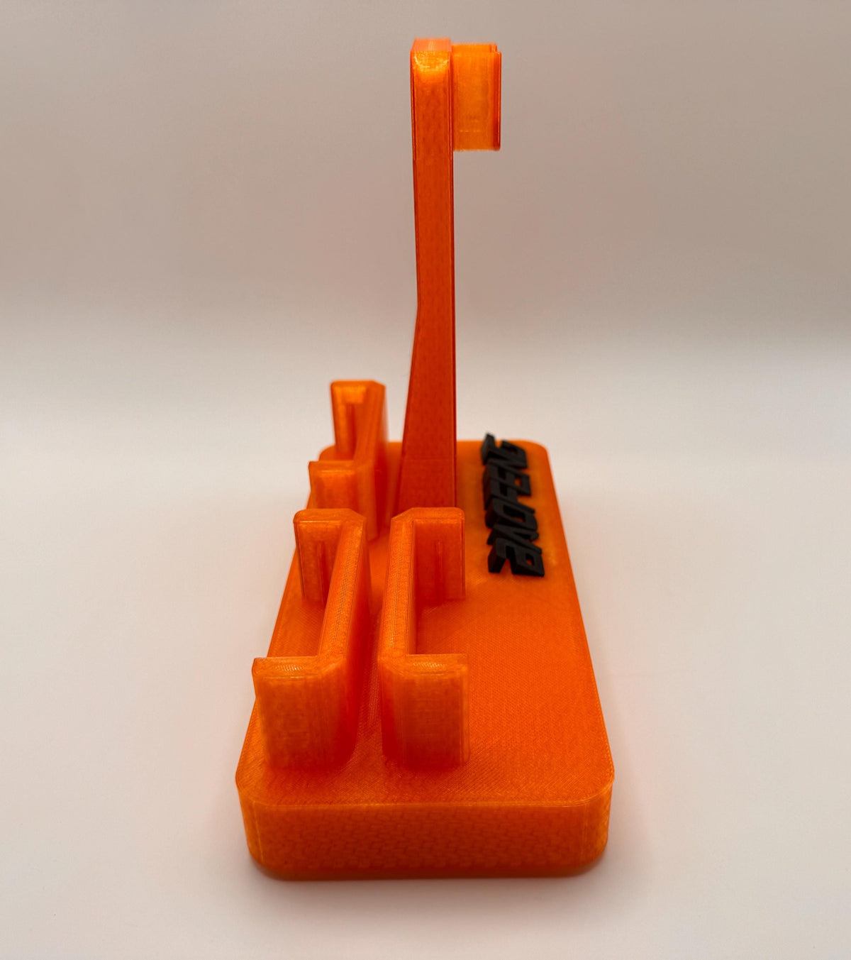 Baofeng UV-5R 25th anniversary transparent orange desk stand – battery slots angled