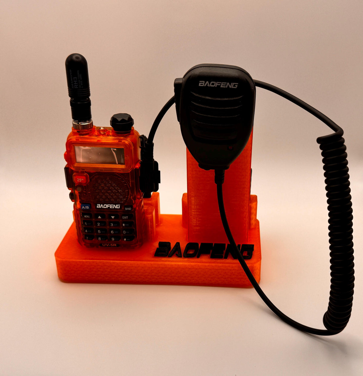 Baofeng UV-5R 25th anniversary transparent orange desk stand – front view with radio