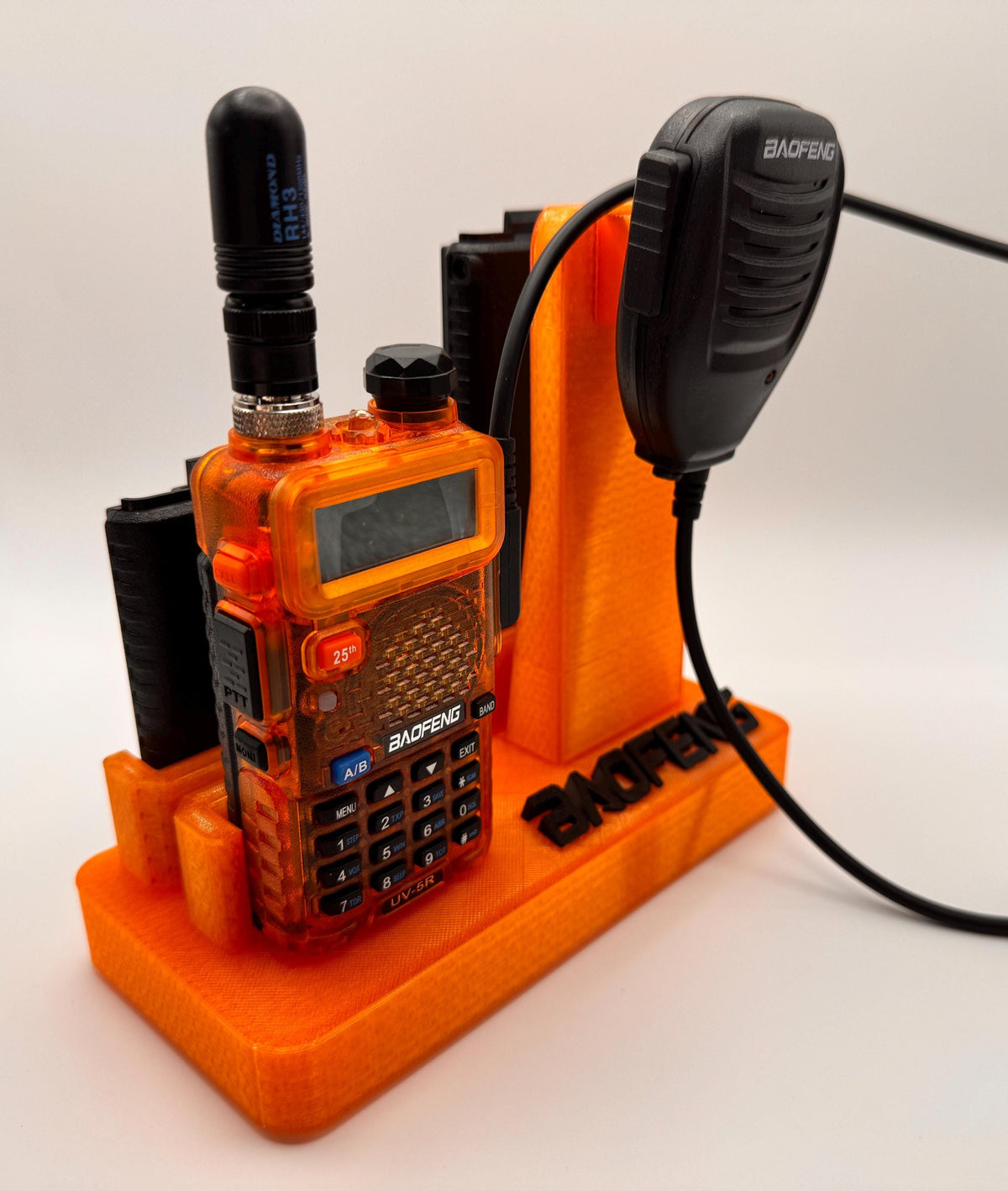Baofeng UV-5R 25th anniversary transparent orange desk stand – radio angled view